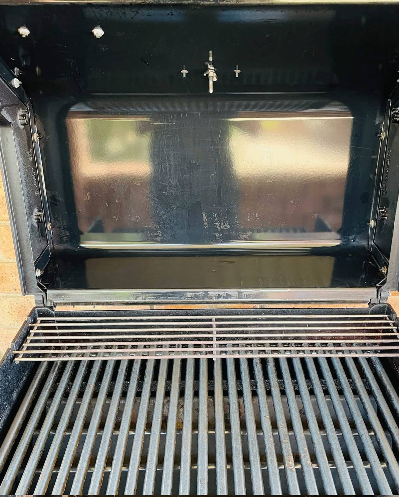 The same BBQ after cleaning, with clean grill bars and a degreased base and hood