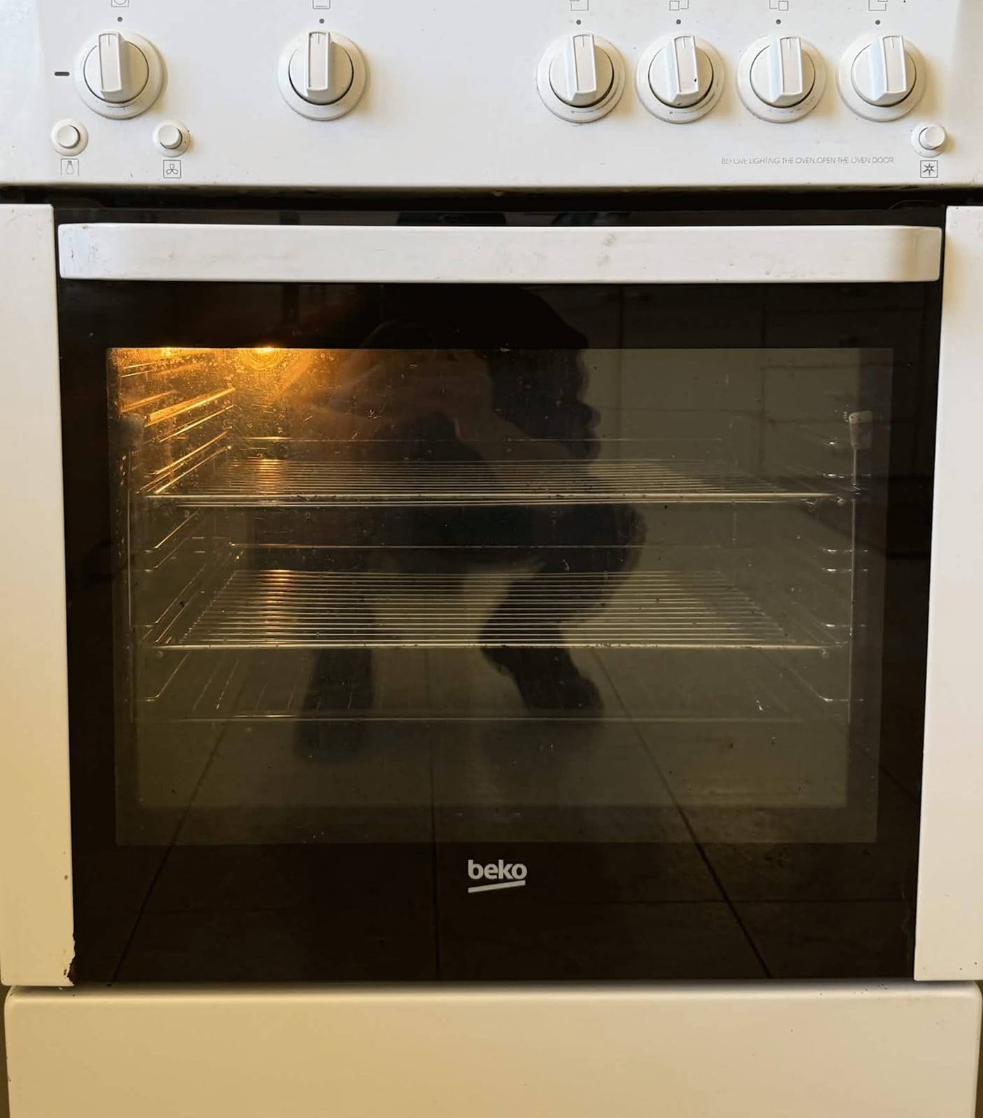 The same freestanding cooker after cleaning, with clear door glass and clean white panels