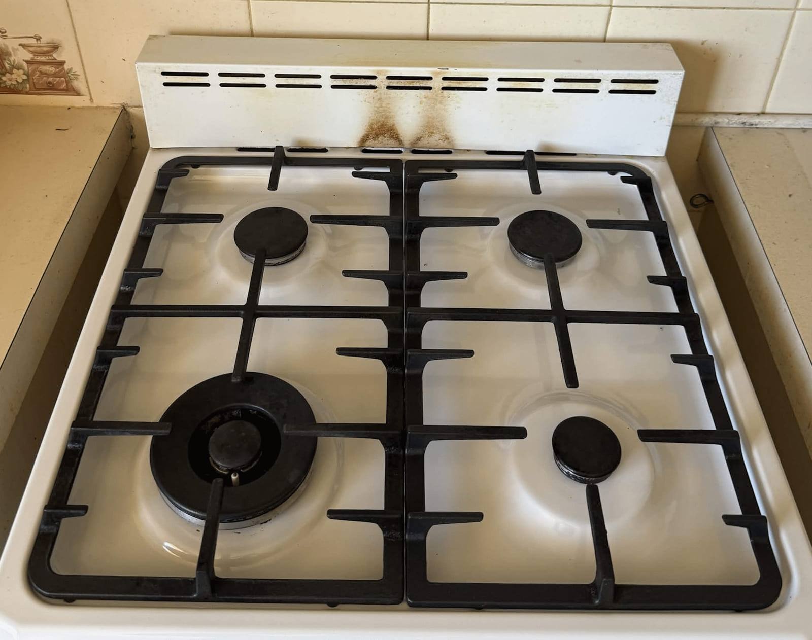 The same cooktop after cleaning, with clean white enamel and degreased cast iron trivets