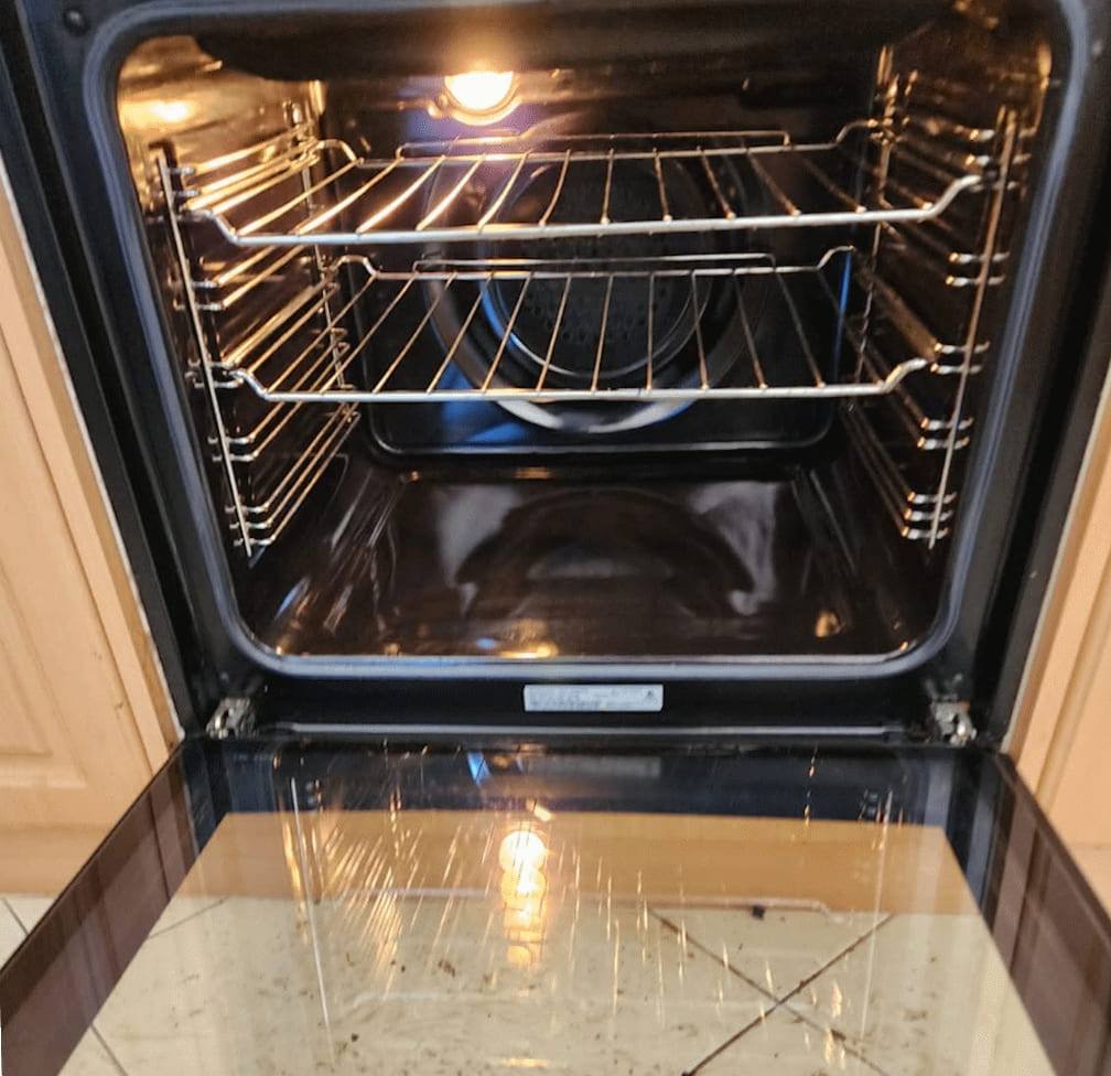 The same oven after cleaning, with clean cavity walls, a clear fan guard and a spotless door tray
