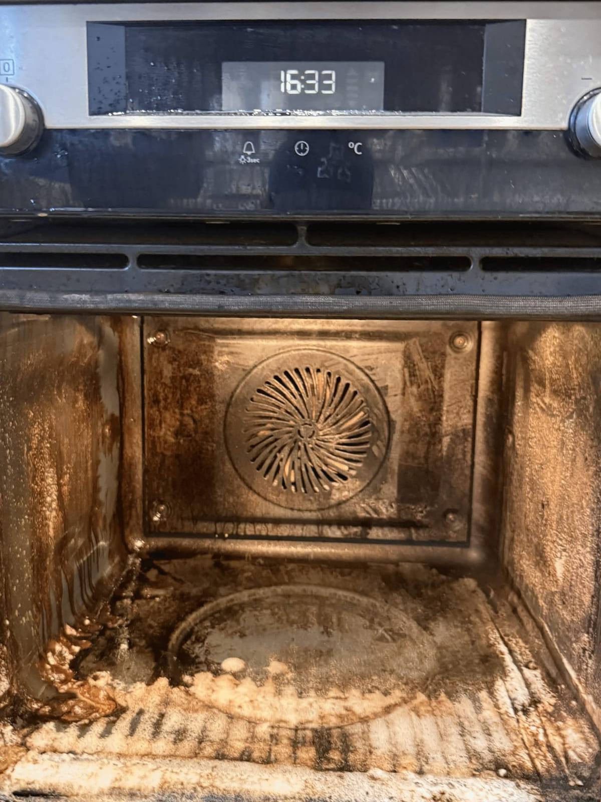 The same oven at 16:33 with the racks removed and degreaser working on the bare cavity