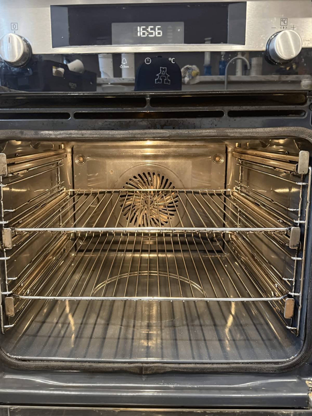The finished wall oven at 16:56 with clean chrome racks refitted and the cavity gleaming